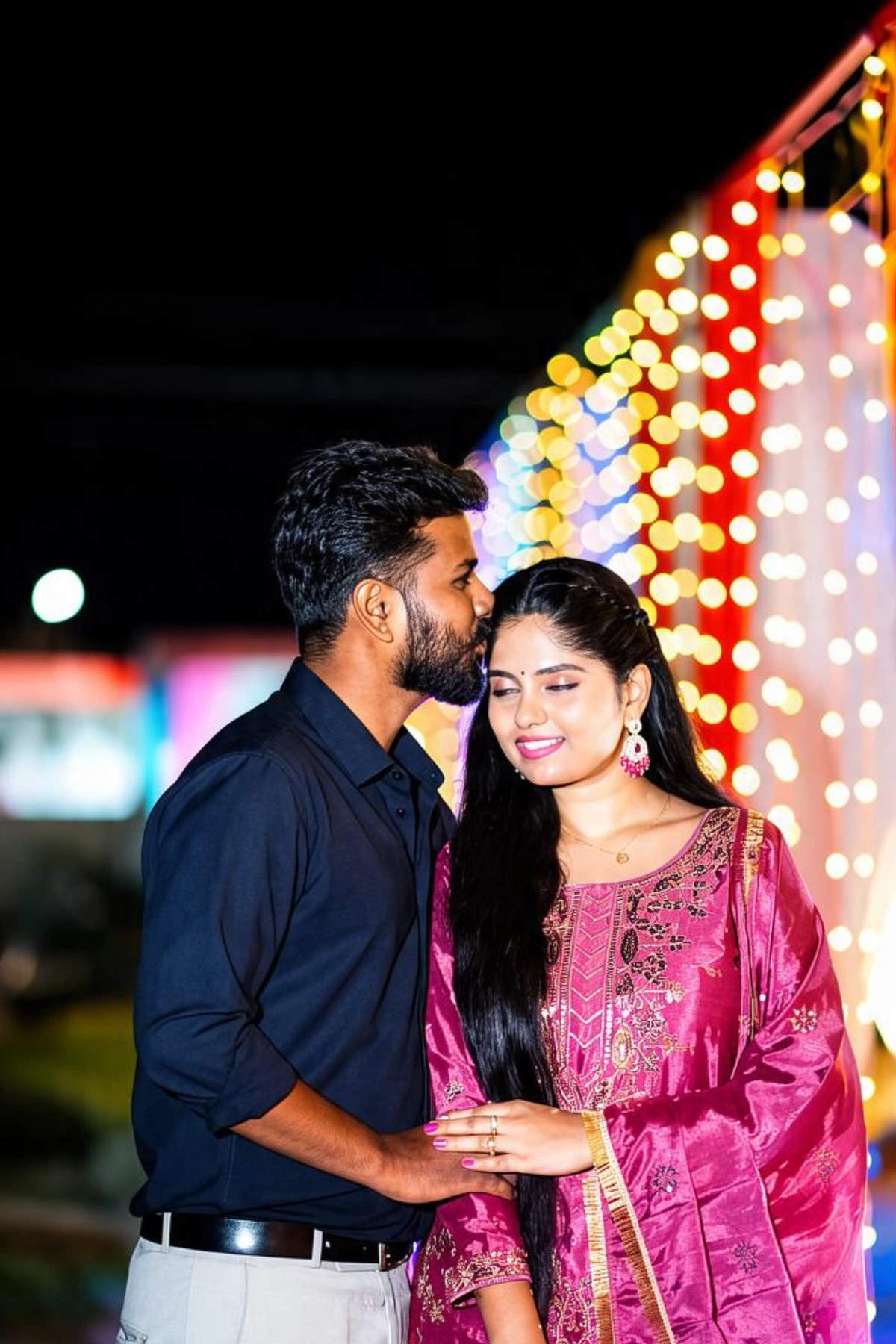 Naveen and Pavana sharing a smile under festive lights
